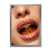 DesignArt 'Izbliza pogled na ženske usne grickajući gumice medvjed' Moderni uokvireni umjetnički tisak